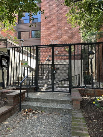 Front view of a multi-story brick building with gated entrance.