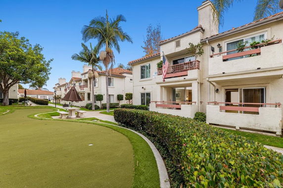 Outdoor view of a residential building with balconies and a landscaped path.