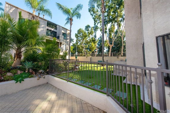 Exterior view of an apartment building with a landscaped area and palm trees.