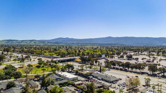Panoramic view of a cityscape with roads and distant mountains.
