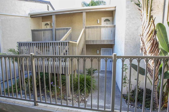 Front view of a two-story building with wooden railings and balconies.