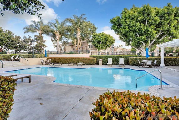 Outdoor swimming pool area with surrounding trees and lounge chairs.