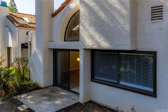 Front view of a building with arched windows and sliding glass doors.