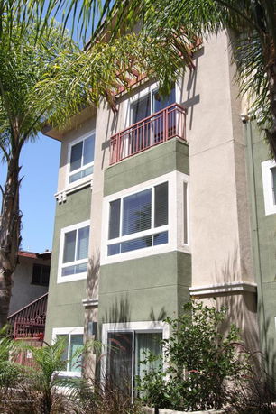 Front view of a multi-story residential building with green and beige exterior.