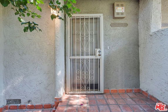 Front view of a house entrance with a metal security door.