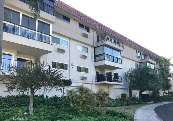Front view of a multi-story apartment building with balconies.