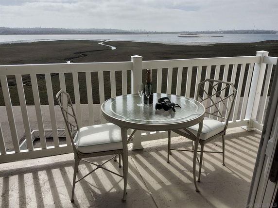 View from a balcony showing a body of water and distant landscape.