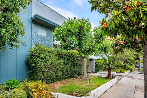 Front view of a modern house with a blue exterior and large windows.