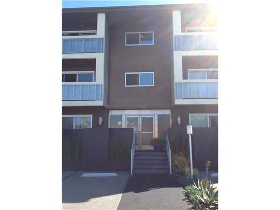 Front view of a three-story apartment building with balconies.