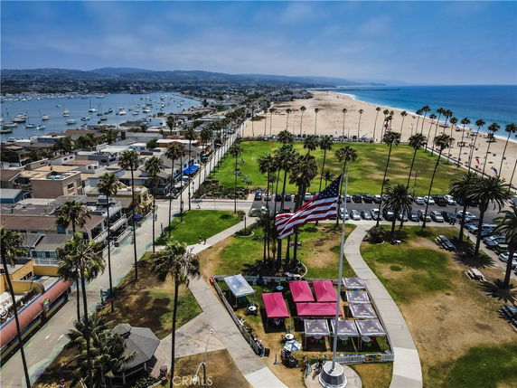 Aerial view of a coastal area with buildings, beach, and marina