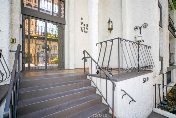 Front view of a building entrance with steps and metal railings.
