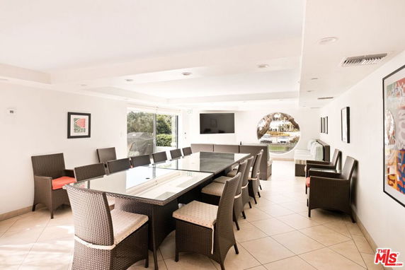 Recreation area with a large table and chairs, featuring modern decor.