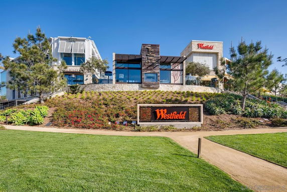 Front view of a commercial building with signage on a landscaped hill.