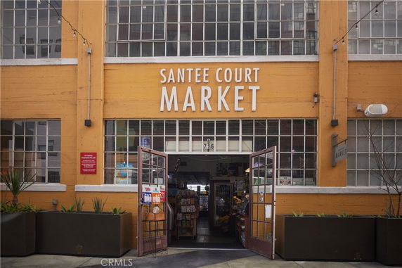 Front view of a market building with large glass windows and an entrance with open double doors.