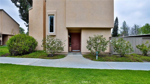 Front view of a house with a beige exterior and a single door entryway.