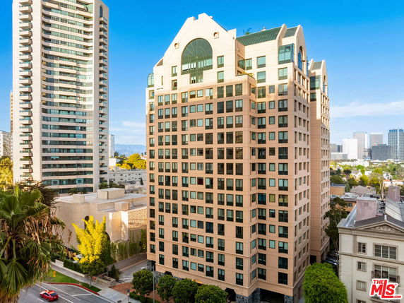 Front view of a tall building with multiple windows and a distinctive roof design.