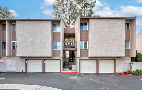 Front view of a multi-story building with garage doors and a central staircase.