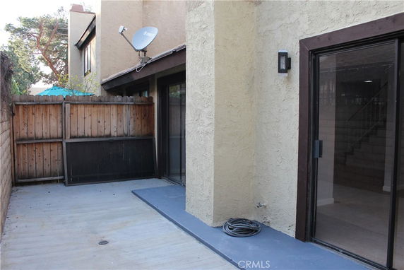 Outdoor area with wooden fencing and a sliding glass door entrance.