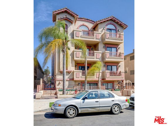 Front view of a four-story apartment building with balconies.