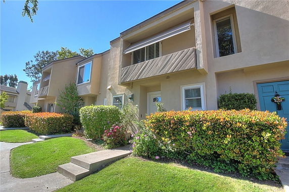 Front view of a two-story townhouse with balconies and a blue door.