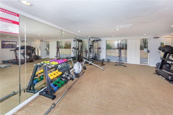 Indoor gym area with exercise equipment and mirrored wall