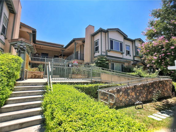 Front view of a multi-level residential building with ramps and stairs.