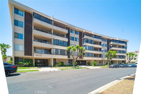 Front view of a multi-story apartment building with multiple balconies.