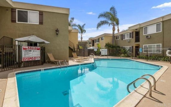 Outdoor swimming pool surrounded by multi-story residential buildings.