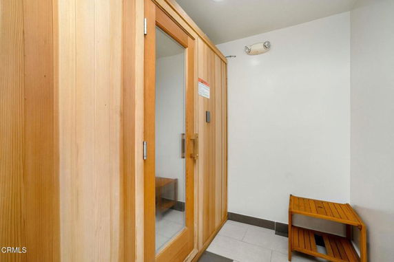 Interior view of a sauna with a wooden door and small bench.