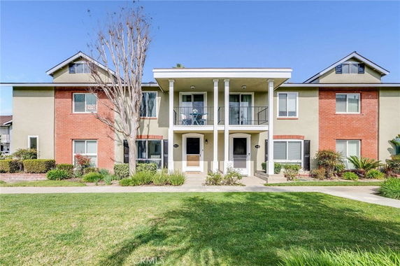 Front view of a two-story residential building with brick and stucco exterior.