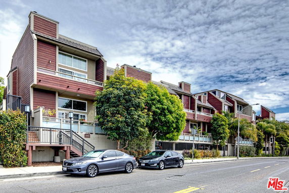 Front view of a multi-story residential building with a modern design and wooden exterior.