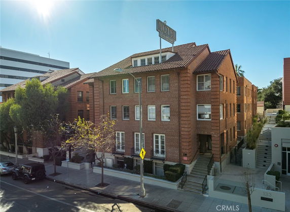 Front view of a three-story brick building with a hotel sign on the roof.
