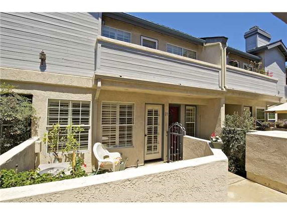 Front view of a two-story residential building with balconies and a small patio.