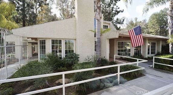 Front view of a house with a single-story and a large American flag displayed.