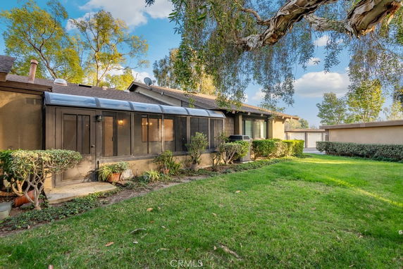 Front view of a house with a greenhouse extension and a well-maintained lawn.