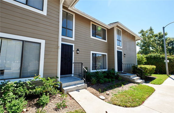 Front view of a two-story duplex with a beige exterior.