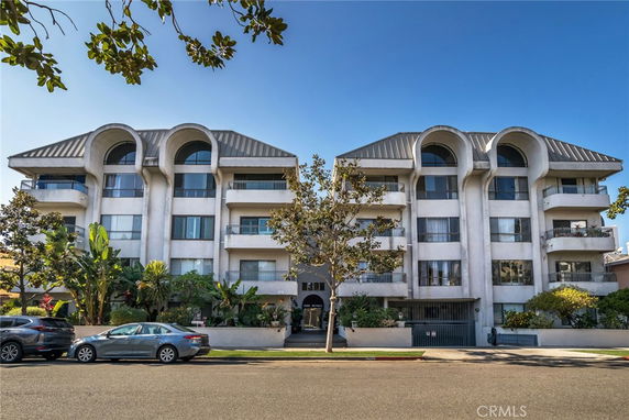 Front view of a multi-story residential building with a modern design and multiple balconies.
