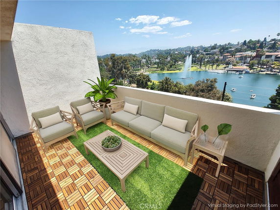 Outdoor patio area overlooking a scenic view of a lake and fountain.