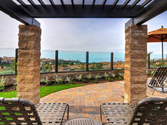 View of surrounding areas with a pergola and seating area in the foreground.