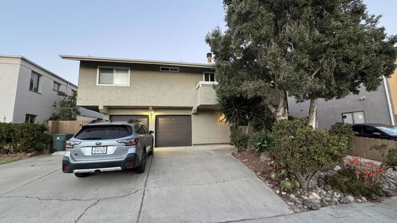 Front view of a two-story house with a garage and driveway.