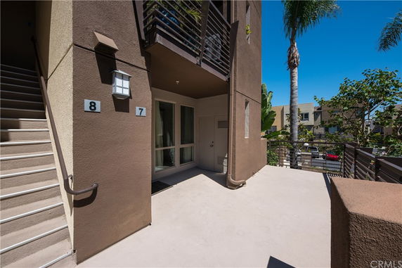 View of an apartment exterior with stairway access and a balcony.