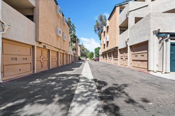 Outdoor view of a row of garages attached to residential buildings.