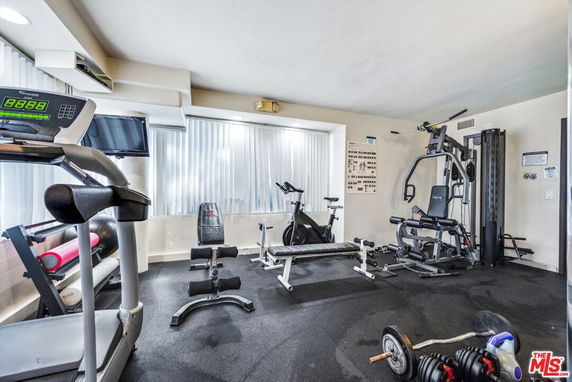 Indoor gym area with fitness equipment including treadmill, bench press, and weights.