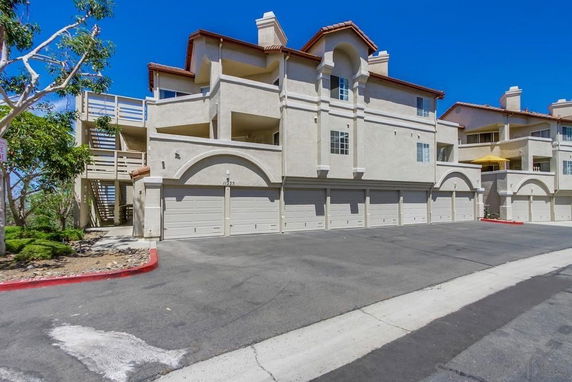 Front view of a multi-story residential building with multiple garages.