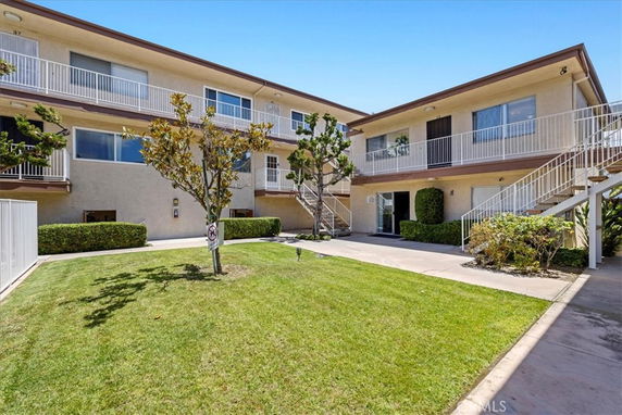 Front view of a two-story residential building with outdoor staircases and balconies.