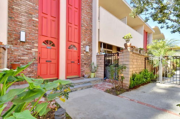 Front view of a building with red doors and brick facade.