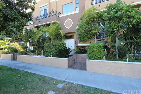 Front view of a multi-story building with balconies and gated entry.