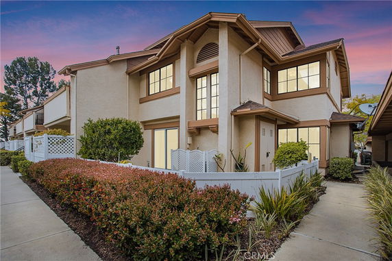 Front view of a two-story house with a beige exterior and brown trim.