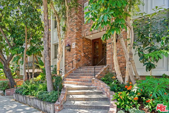 Front view of a brick exterior building with stairs leading to entrance