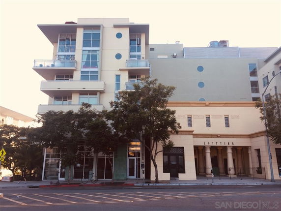Front view of a multi-story building with balconies and large windows.